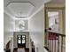 View from upstairs landing to the front entrance hall featuring an elegant chandelier and arched window at 6770 Ulster Ct, Alpharetta, GA 30005