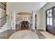 Grand foyer with hardwood floors, elegant columns, staircase, and a view into the dining room at 6770 Ulster Ct, Alpharetta, GA 30005