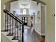 Spacious foyer with staircase, hardwood floors, chandelier and view to entry door at 6770 Ulster Ct, Alpharetta, GA 30005