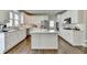 Bright kitchen with white cabinets, a kitchen island, stainless steel appliances, and beautiful hardwood floors at 6770 Ulster Ct, Alpharetta, GA 30005