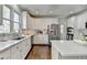 Bright kitchen features white cabinetry, stainless steel appliances, and a large center island at 6770 Ulster Ct, Alpharetta, GA 30005