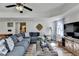 Bright living room features a large sectional, ceiling fan, and wood-look flooring at 6770 Ulster Ct, Alpharetta, GA 30005