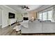 Open living room with a ceiling fan, fireplace, large sofa, and large windows for ample natural lighting at 6770 Ulster Ct, Alpharetta, GA 30005