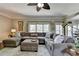 Large open living room with a sectional sofa, decorative rug, fan, and natural light at 6770 Ulster Ct, Alpharetta, GA 30005