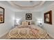 Comfortable main bedroom featuring a tray ceiling, carpet, and decorative accents at 6770 Ulster Ct, Alpharetta, GA 30005