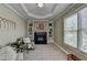 Bright sitting room offers a tiled fireplace, custom shelves, and comfortable seating near windows at 6770 Ulster Ct, Alpharetta, GA 30005