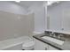 Bathroom featuring granite counters, modern fixtures, white cabinets, and a bathtub with white tile at 9415 Martin Rd, Roswell, GA 30076