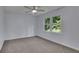 This bedroom features neutral carpet, a ceiling fan, and a window that brings in natural light at 9415 Martin Rd, Roswell, GA 30076