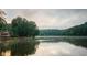 A beautiful view of the lake and surrounding trees, with a boat peacefully cruising on the water at 9415 Martin Rd, Roswell, GA 30076