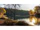 Peaceful lake view with people enjoying the scenery and a dog relaxing nearby at sunset at 9415 Martin Rd, Roswell, GA 30076