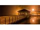 Night time view of dock with wooden railings leading to a gazebo on a misty lake at 9415 Martin Rd, Roswell, GA 30076