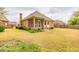 Backyard view of brick home with screened porch, mature trees and landscaping at 2330 Burlington Ln, Snellville, GA 30078