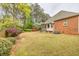 View of the backyard with lovely landscaping surrounding brick home with a screened porch at 2330 Burlington Ln, Snellville, GA 30078