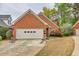 Charming brick home features a two-car garage, manicured lawn and mature trees at 2330 Burlington Ln, Snellville, GA 30078