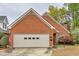 Charming brick home features a two-car garage, manicured lawn and mature trees at 2330 Burlington Ln, Snellville, GA 30078
