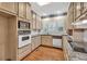 Traditional kitchen with wood floors, granite countertops, and white appliances at 2330 Burlington Ln, Snellville, GA 30078