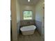 Freestanding tub with stylish fixtures set against gray tile in a contemporary bathroom at 4824 Highway 20 Se, Conyers, GA 30013