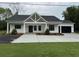 Charming one-story home with a black roof, white siding and a large driveway at 4824 Highway 20 Se, Conyers, GA 30013