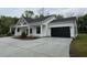 Charming one-story home with a black garage door, white siding and a large driveway at 4824 Highway 20 Se, Conyers, GA 30013