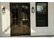 Close-up of an elegant dark wood front door with glass panels and sleek modern black hardware at 4824 Highway 20 Se, Conyers, GA 30013