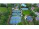 Aerial view of community tennis courts and swimming pool surrounded by lush green trees and greenery at 5450 Piney Grove Dr, Cumming, GA 30040