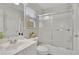 All-white bathroom featuring vanity, toilet and shower-tub combination with glass doors at 5450 Piney Grove Dr, Cumming, GA 30040