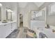 Bright bathroom featuring double vanities, a soaking tub, and a separate shower with glass door at 5450 Piney Grove Dr, Cumming, GA 30040