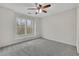 Bright bedroom with ceiling fan, plush carpet, and large window overlooking nature at 5450 Piney Grove Dr, Cumming, GA 30040