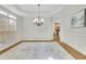 Elegant dining room features hardwood floors, tray ceiling and wainscotting with adjacent open area at 5450 Piney Grove Dr, Cumming, GA 30040