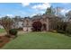Beautiful two-story brick home with a well-manicured lawn and a three-car garage at 5450 Piney Grove Dr, Cumming, GA 30040