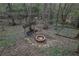 Backyard fire pit with swing and stone features amid lush trees and leaves at 5450 Piney Grove Dr, Cumming, GA 30040