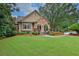 Charming home exterior with a well-manicured lawn, stone accents, and colorful landscaping at 5450 Piney Grove Dr, Cumming, GA 30040