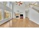 Sun-filled living room with fireplace, soaring ceilings, and large windows overlooking the backyard at 5450 Piney Grove Dr, Cumming, GA 30040