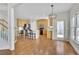 Open-concept living space with hardwood floors seamlessly integrating kitchen and dining area at 5450 Piney Grove Dr, Cumming, GA 30040