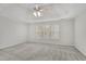 A spacious bedroom with neutral tones, plush carpet, and natural light from a large window at 5450 Piney Grove Dr, Cumming, GA 30040