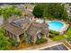 Aerial view of a community pool with lounge chairs, a pool house, mature trees and lawn area at 756 Stickley Oak Way, Woodstock, GA 30189