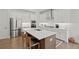 Open concept kitchen with stainless appliances, white cabinetry, and hardwood floors at 756 Stickley Oak Way, Woodstock, GA 30189