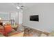 Bright living room with sofa, decorative pillows, a ceiling fan, hardwood floors, and a wall-mounted television at 756 Stickley Oak Way, Woodstock, GA 30189