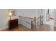 Staircase with hardwood floors, elegant wood and metal railings, and a decorative chest with a lamp at 756 Stickley Oak Way, Woodstock, GA 30189