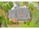Aerial view of a brick home with a back porch overlooking lush greenery and landscaping at 800 Flathead Pass, Suwanee, GA 30024