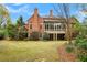 Expansive backyard with lush lawn and mature trees surrounding a beautiful brick home at 800 Flathead Pass, Suwanee, GA 30024