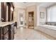 Spacious bathroom featuring a soaking tub, glass shower, and dual sink vanity with marble countertops at 800 Flathead Pass, Suwanee, GA 30024