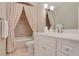 Bathroom showcasing a vanity with white cabinets and a tub-shower combo with a patterned curtain at 800 Flathead Pass, Suwanee, GA 30024