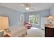 Light blue bedroom with a bed, sitting chair, and bright window view at 800 Flathead Pass, Suwanee, GA 30024