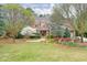 A beautiful home with a lush green lawn, mature trees, and a stone and brick exterior at 800 Flathead Pass, Suwanee, GA 30024