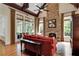 Inviting living room featuring a stone fireplace, exposed wood beams, and large windows showcasing the outdoor view at 800 Flathead Pass, Suwanee, GA 30024