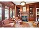 Elegant living room featuring a fireplace, wood paneling, built-in bookshelves, and French doors at 800 Flathead Pass, Suwanee, GA 30024