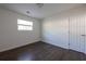 Simple bedroom featuring hardwood floors, white walls, and a closet door at 4704 Apache Sw Trl, Atlanta, GA 30331