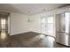 Open dining area with a chandelier, hardwood floors, stainless steel refrigerator, and natural light from glass paneled doors at 4704 Apache Sw Trl, Atlanta, GA 30331