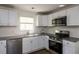 Bright kitchen featuring stainless steel appliances, granite countertops, white subway tile backsplash, and hardwood flooring at 4704 Apache Sw Trl, Atlanta, GA 30331
